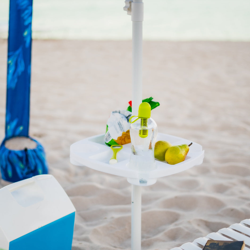 A white umbrella on a beach, accompanied by a AMMSUN 17