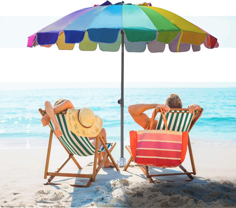 Two people relax beneath AMMSUN 7.5ft rainbow travel beach umbrella with sand anchor on a sandy beach