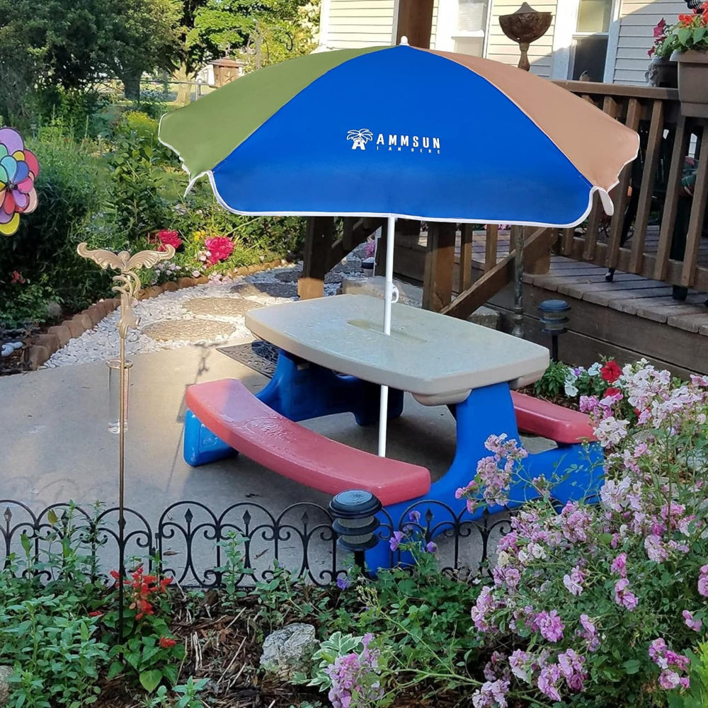 A colorful AMMSUN 5ft Kid Umbrella for toddler camping chair, Green Blue beach shade umbrella is placed on a white picnic table. 