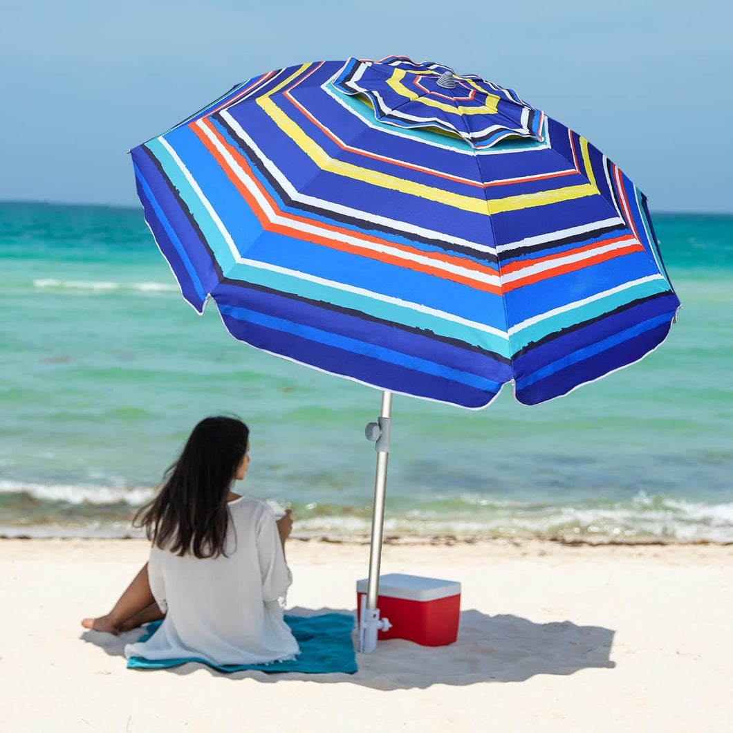 Awoman is sitting under AMMSUN 7ft Multicolor blue stripes Beach large outdoor umbrella with sand anchor