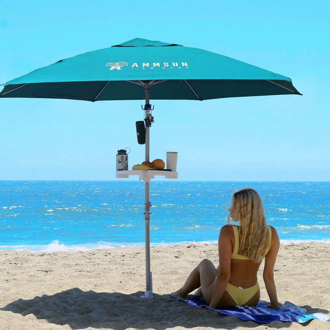 A woman relaxes under AMMSUN 8ft
large size teal beach umbrellas for sand heavy duty wind portable with sand anchor