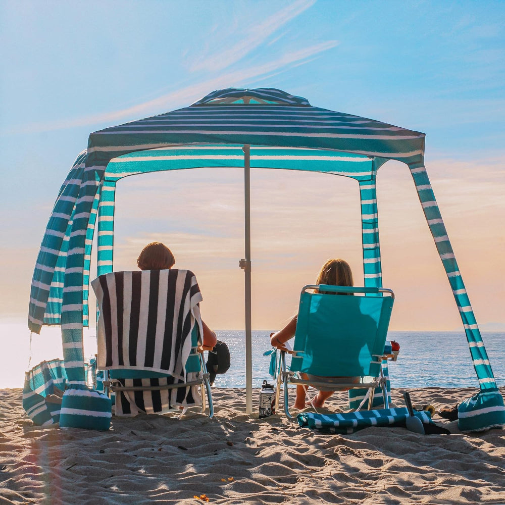 Two individuals relax under an AMMSUN 6.2'×6.2' royal turquoise beach cool cabana tent with privacy sunwall