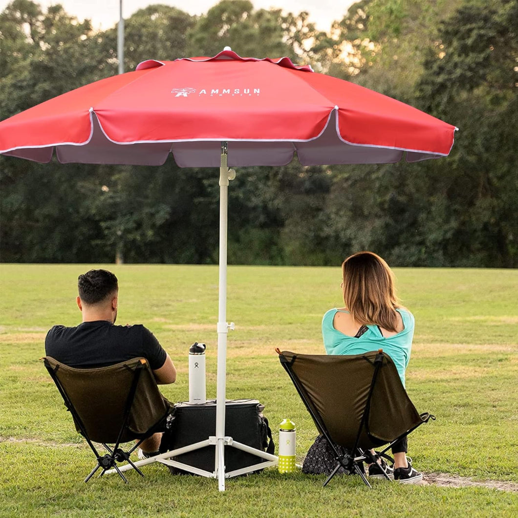 Two people are seated inchairs under AMMSUN 6.5ft pink sports umbrella with stand in a field