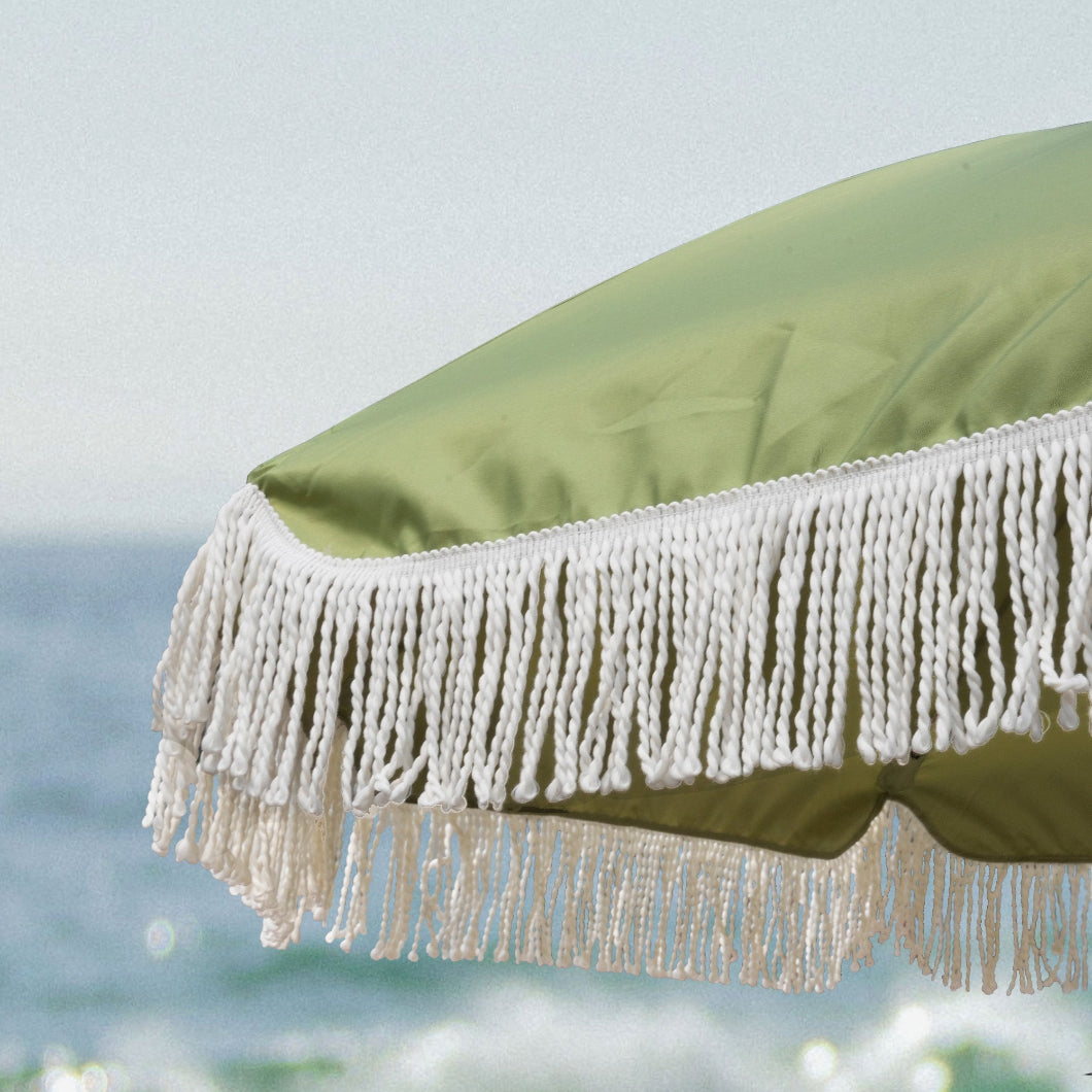 AMMSUN 7ft green high wind beach umbrella adorned with white fringes, providing shade for patio