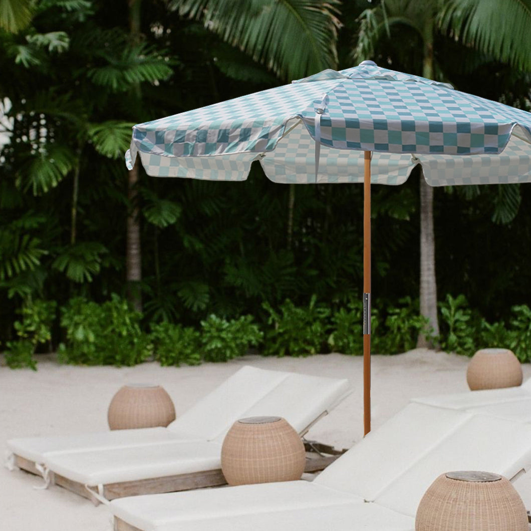 A serene beach scene featuring lounge chairs and AMMSUN 7.8ft green check sun umbrella uv protection for beach