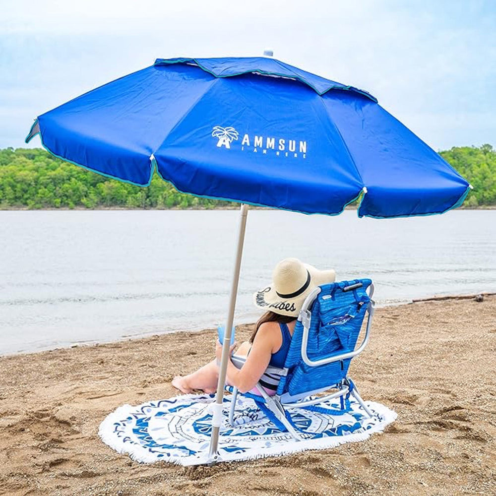 A woman sit under AMMSUN 6ft navy blue folded beach umbrellas for sand heavy duty wind with sand anchor