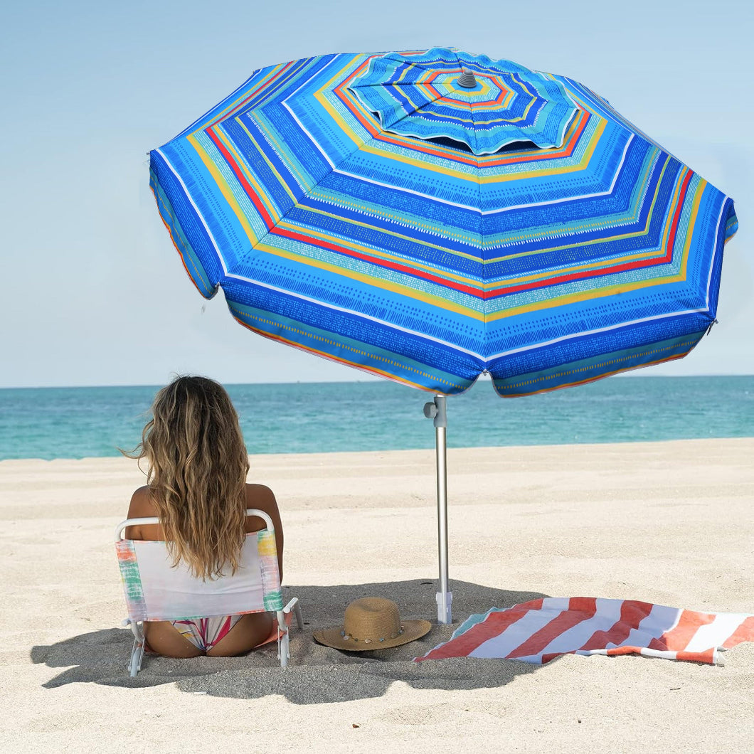 A woman sits on the beach under a large AMMSUN 7ft mariana's tear green sombrilla de patio with sand anchor