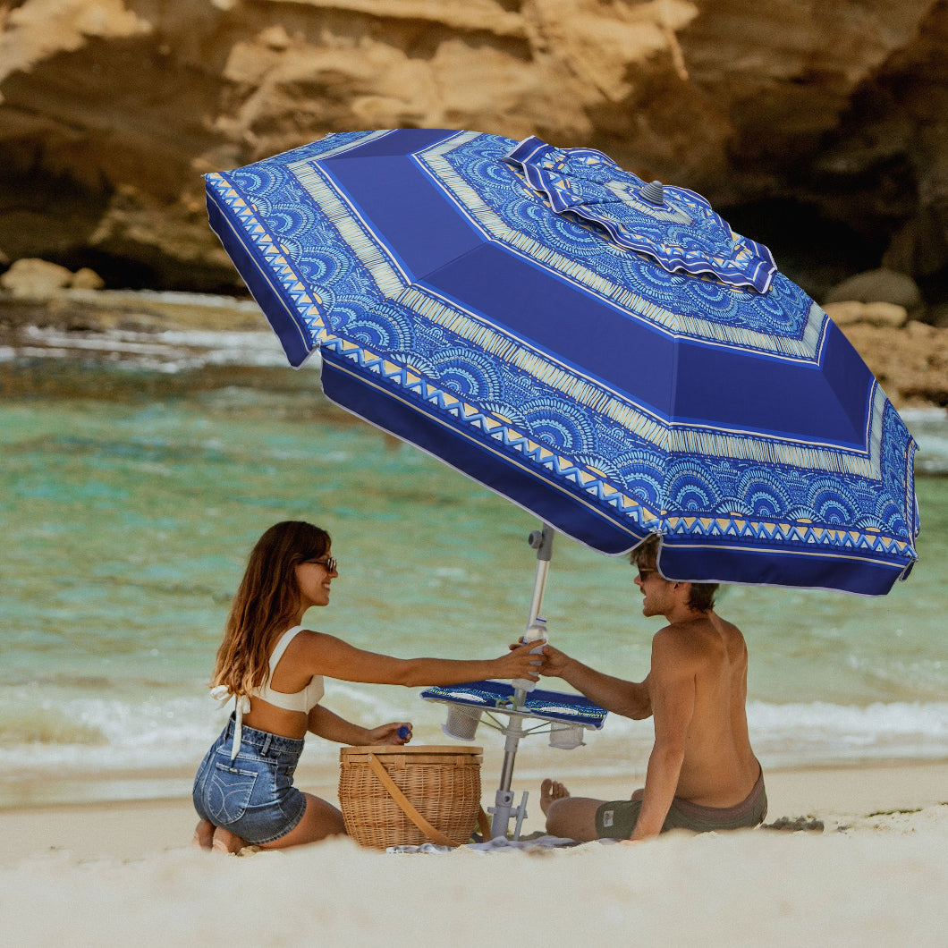 A couple relaxes under AMMSUN 7FT haute stripes travel beach umbrella with sand anchor and table