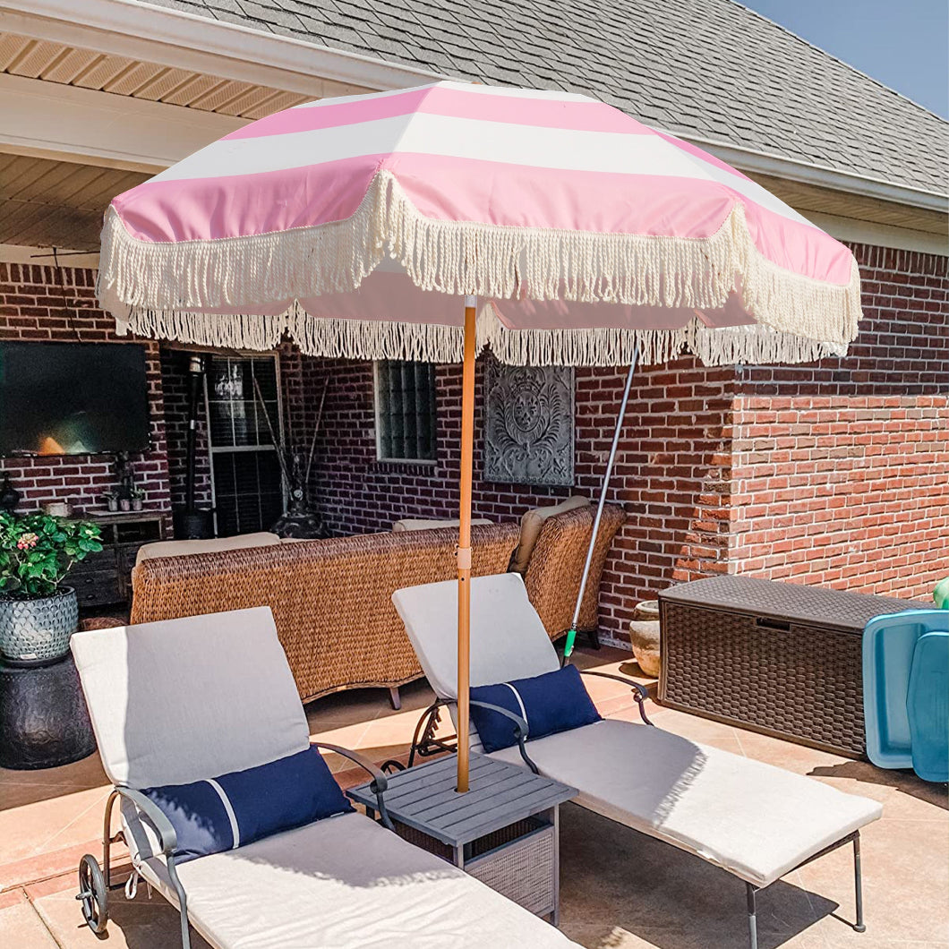 AMMSUN pink and white striped fringe backyard umbrella with tassel stands elegantly on a patio.