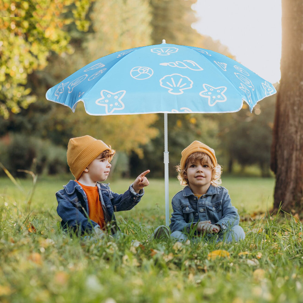 Two children seated on the grass, sheltered by AMMSUN 5ft umbrellas for kids, Shell Blue beach chair umbrella