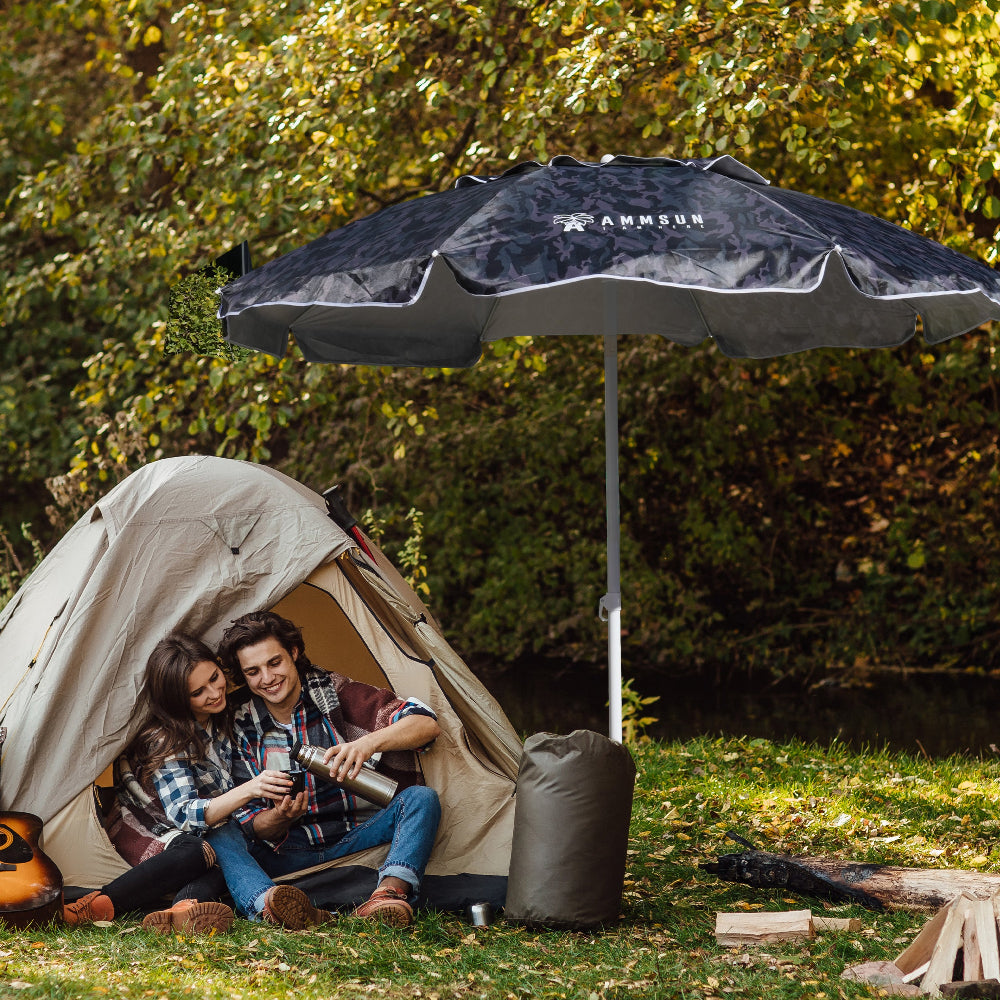 A couple enjoys a peaceful moment sitting under an AMMSUN 6.5ft Camouflage best heavy duty beach umbrella