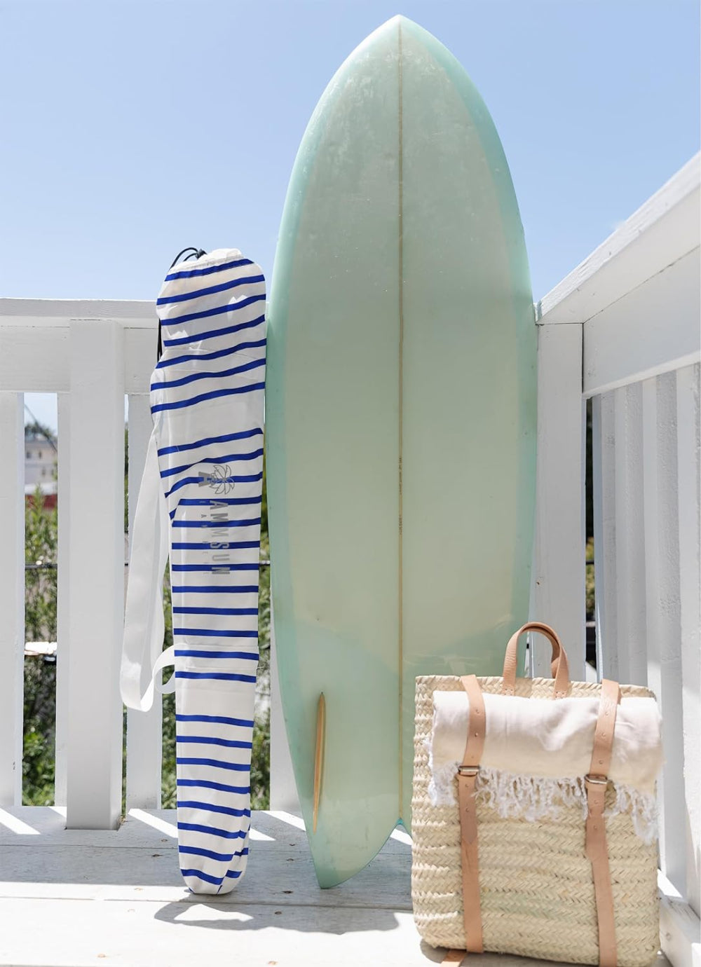 A white deck featuring a carry bag for AMMSUN 6.5ft blue wave beach umbrella clearance with Fringe