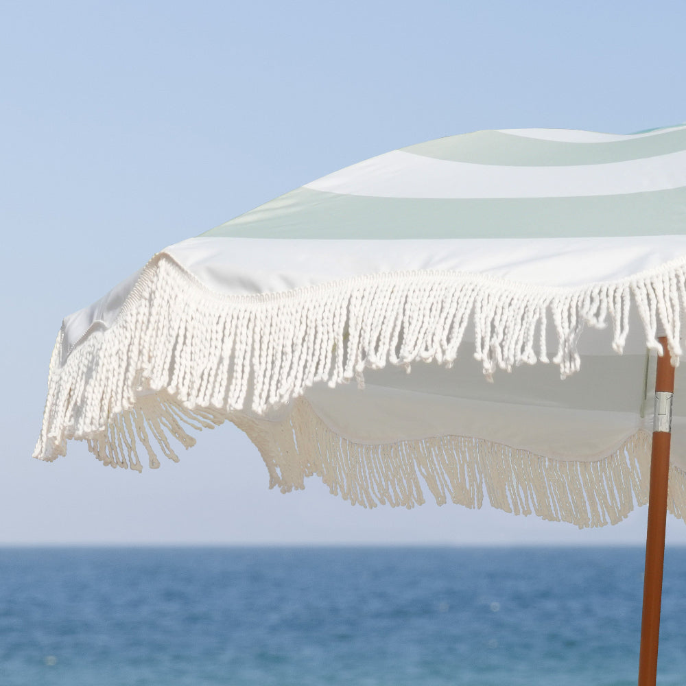 A colorful AMMSUN 6.5ft Vintage Green fringe umbrella adorned with a decorative fringe outdoor umbrella for beach