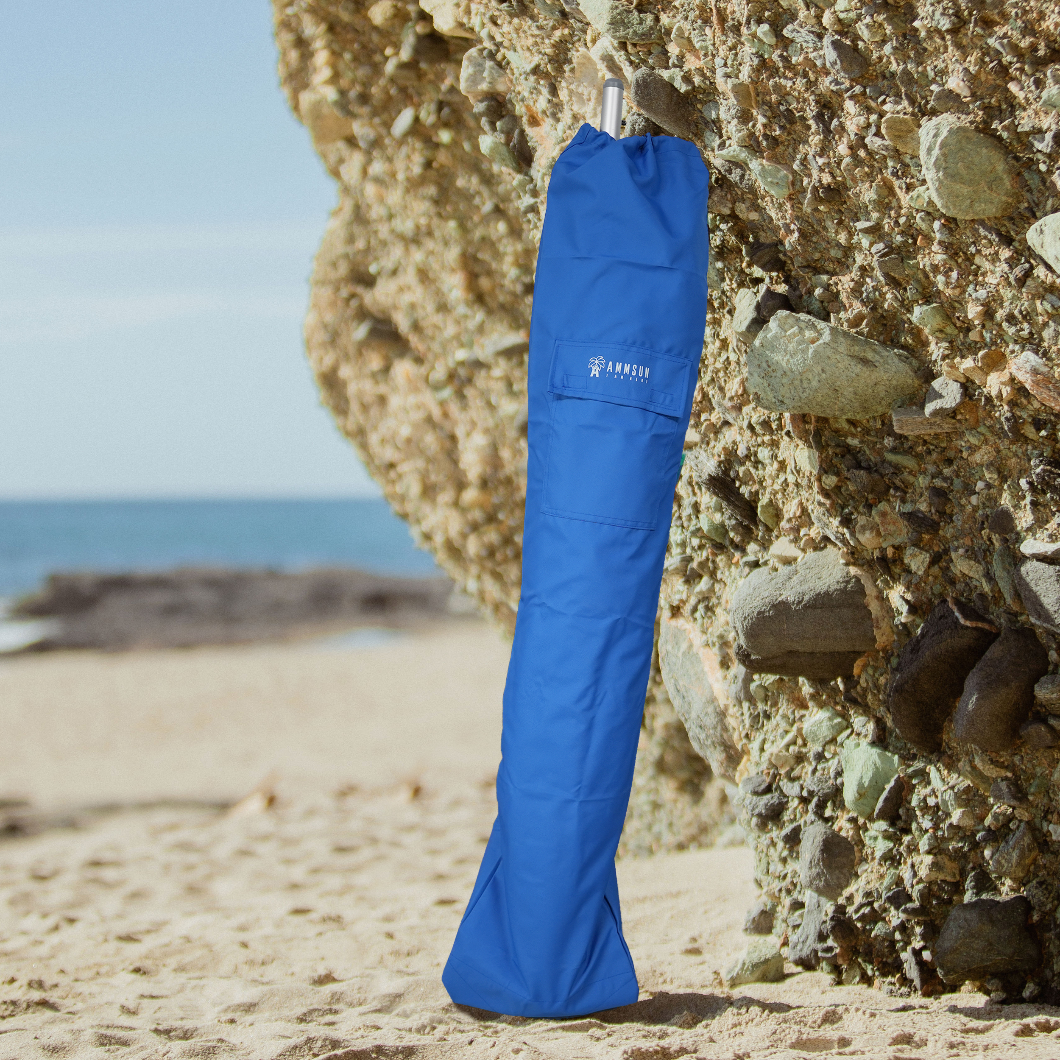 AMMSUN blue umbrella carrying bag for sombrilla de playaresting on a rock