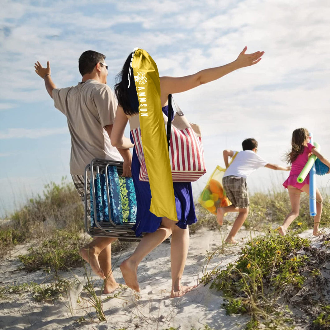 A family of four walks on the beach, carrying AMMSUN yellow 6.5ft portable beach umbrella with stand in the bag