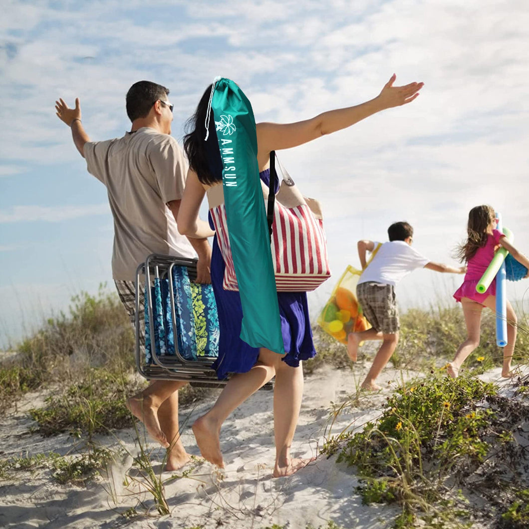 A family of four walks along the sandy beach, carrying bag with AMMSUN 6.5ft portbable sports umbrella with stand