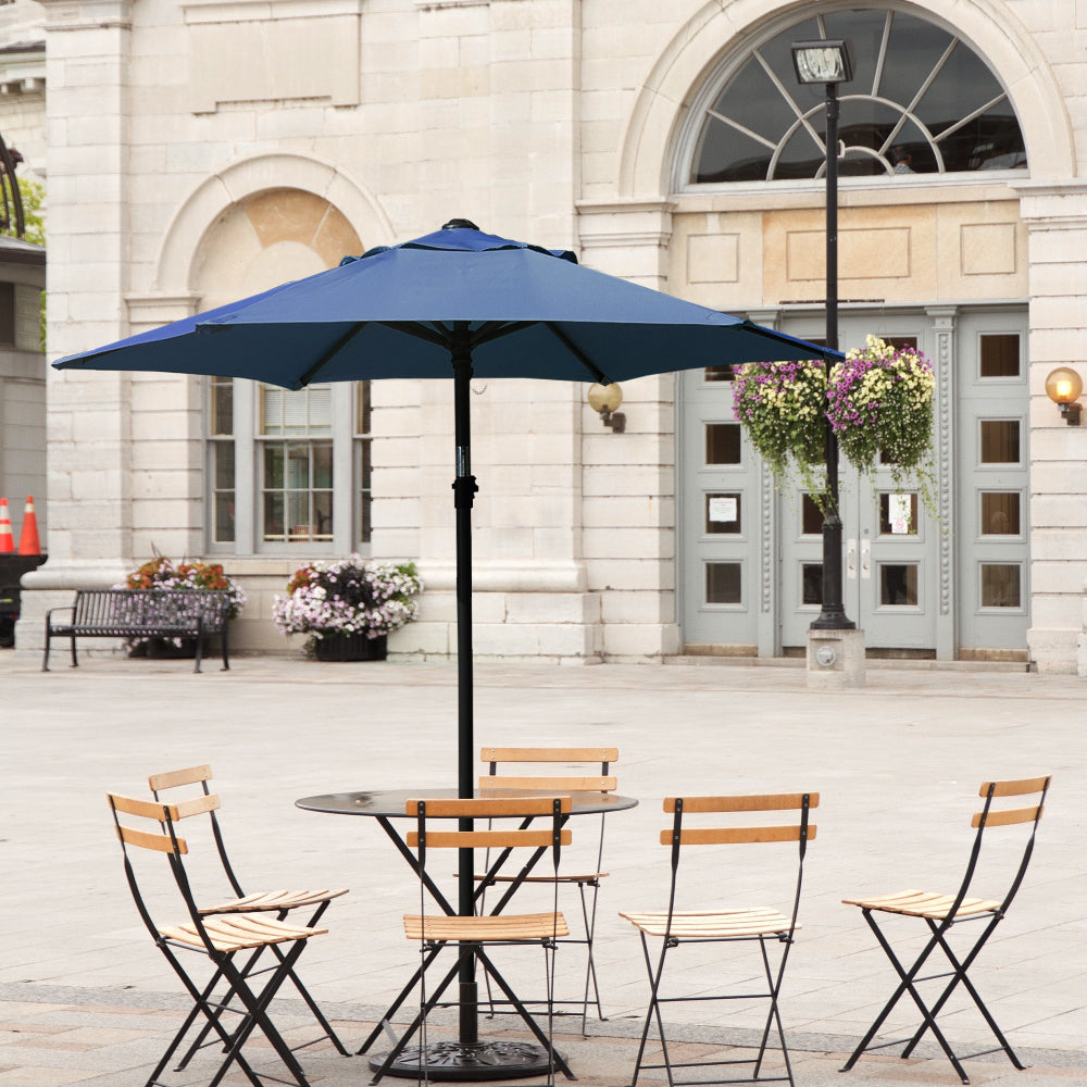 An outdoor patio scene featuring a table and four chairs under AMMSUN 6ft dark blue outdoor patio umbrella small