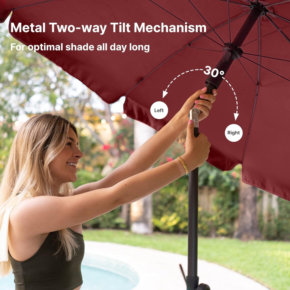 A woman using tilt to adjust the AMMSUN 6.5ft maroon high wind patio umbrella for patio umbrella table to a 30° angle