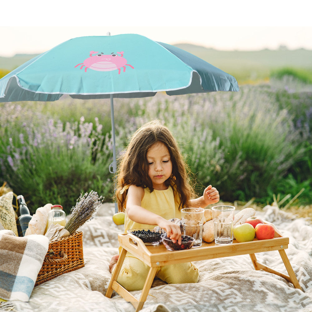 A young girl sits beneath AMMSUN 5ft umbrellas kids, Green Grab girl umbrella for kids 6-12yrs, enjoying a picnic