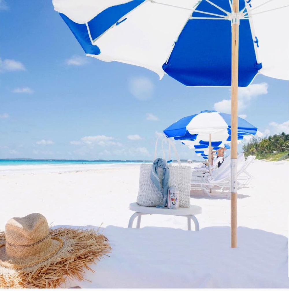 A serene beach featuring vibrant blue white AMMSUN 7.5ft commercial grade heavy duty beach umbrellas