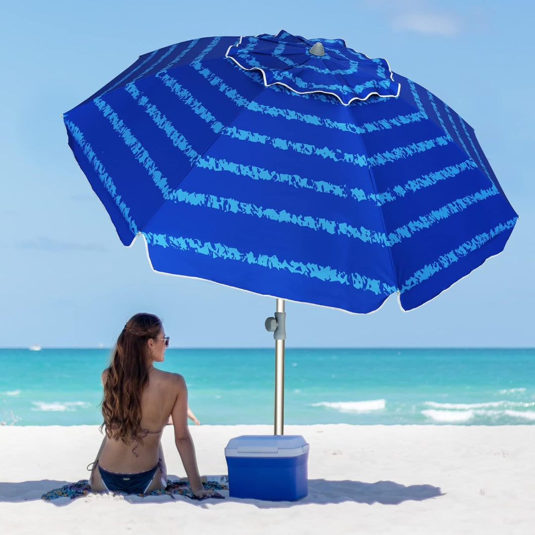 A woman is sitting under AMMSUN 7ft blue pattern beach umbrellas for sand with beach umbrella sand anchor
