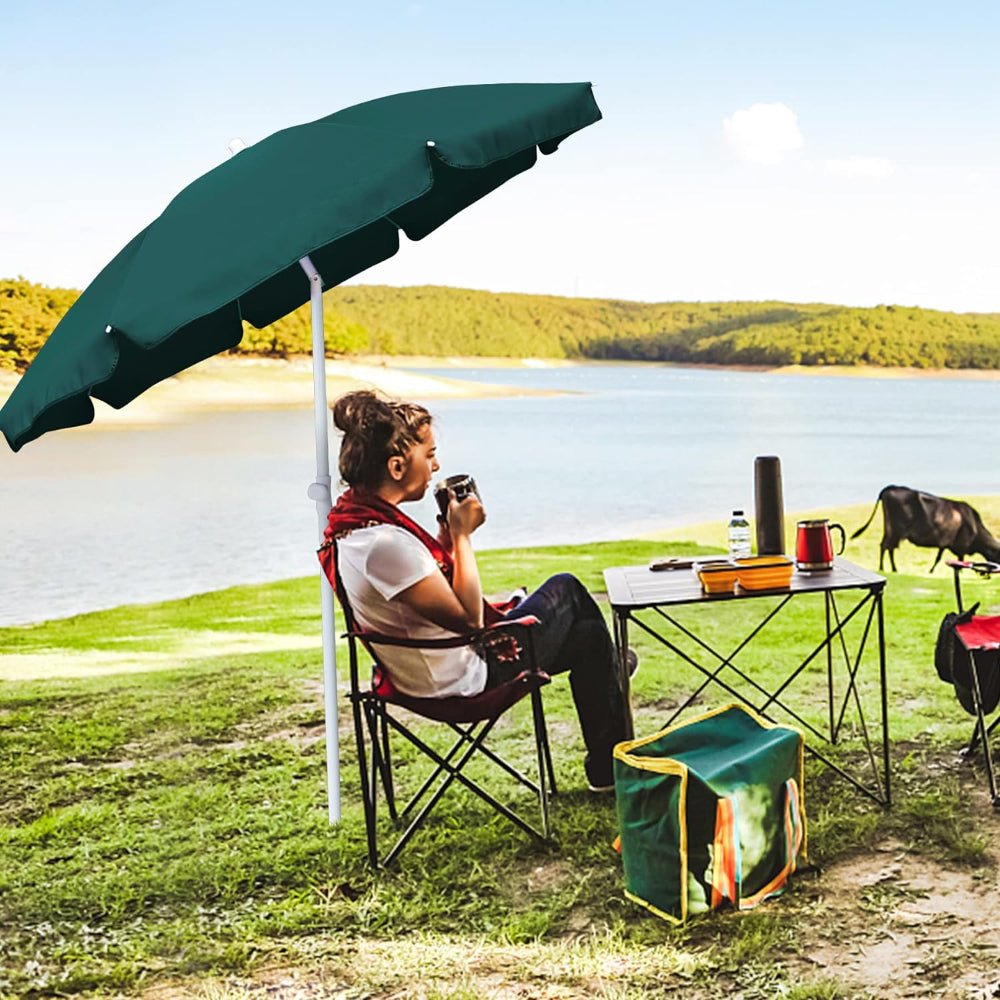 A woman seated at a picnic table, sheltered by AMMSUN 6ft green large umbrella outdoor patio