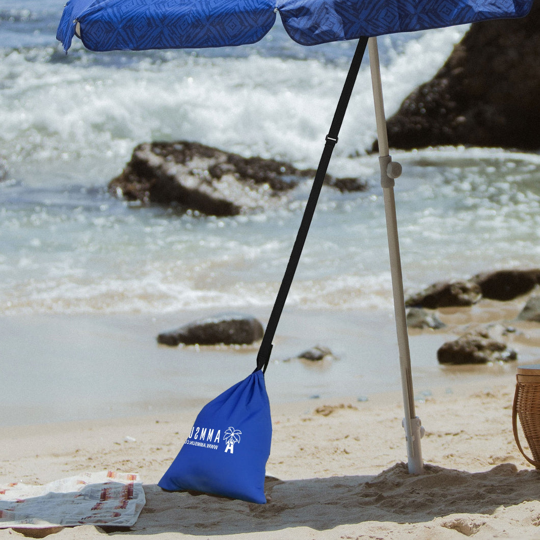 A blue umbrella is standing on the beach with AMMSUN blue beach umbrella sand bag for umbrella weight