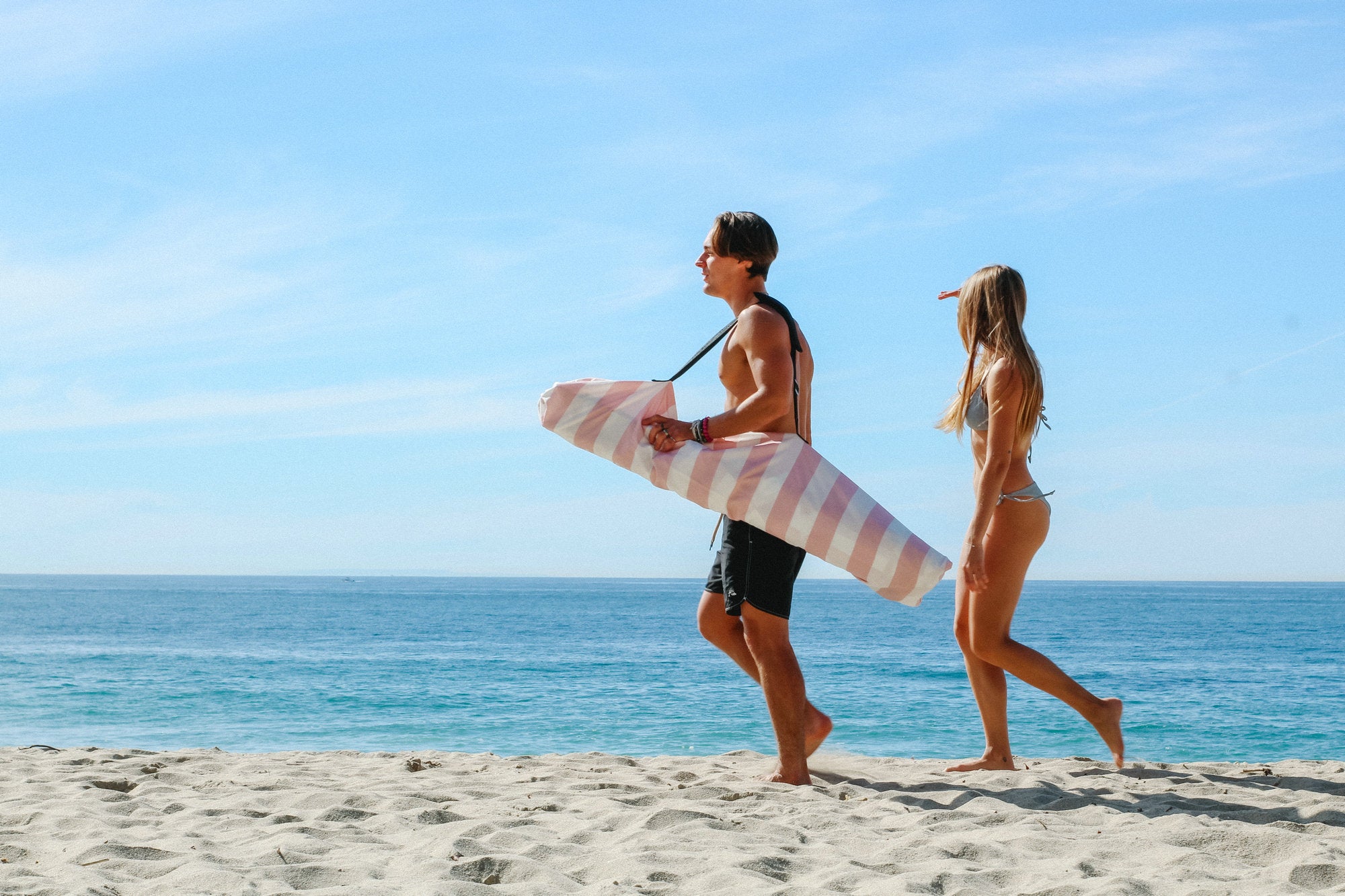 Two people walking on beach with a bag for AMMSUN camping canopy tent