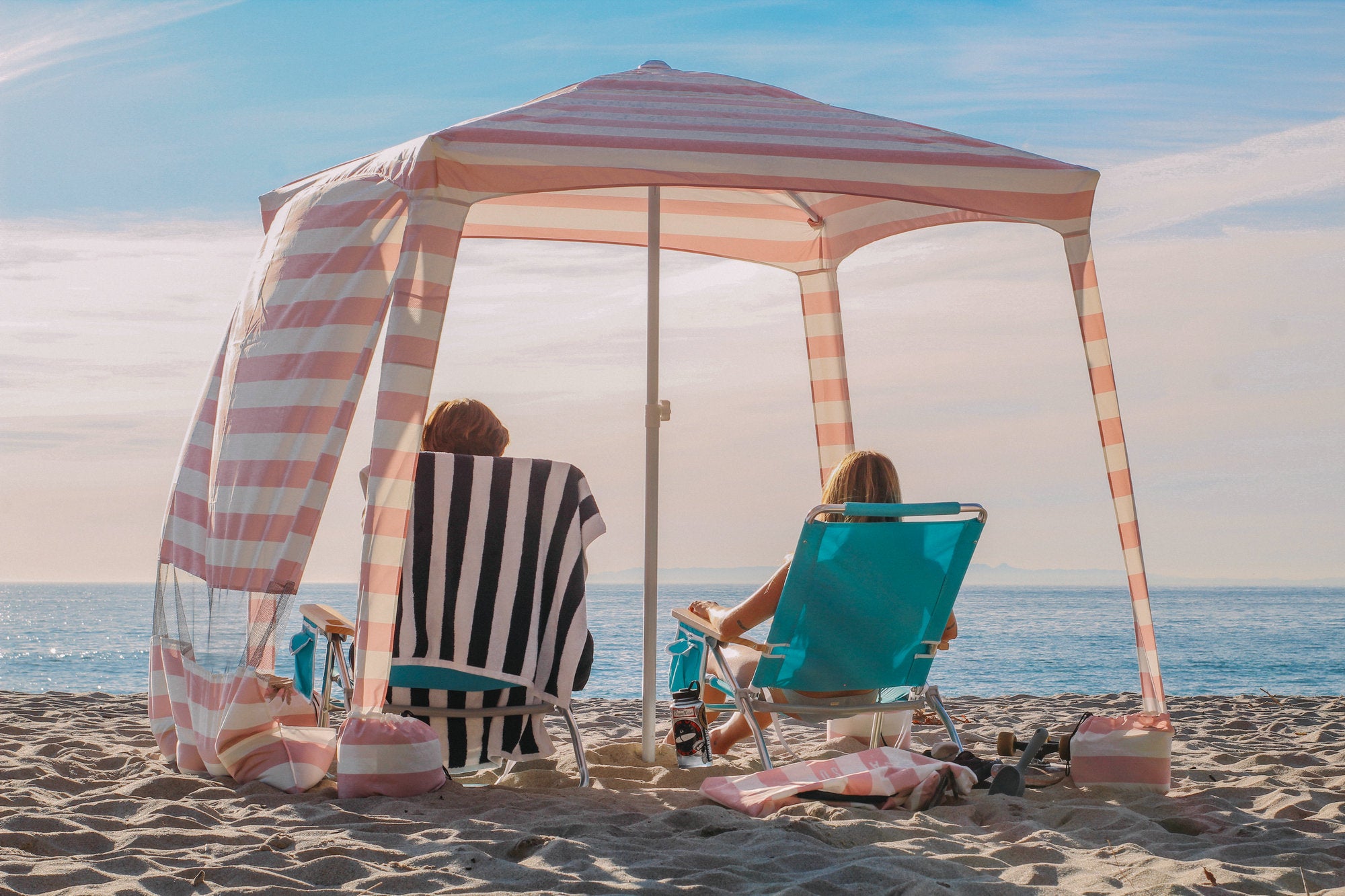 Two people sitting under AMMSUN pink 6.2'×6.2' beach canopy tent sun shade on beach