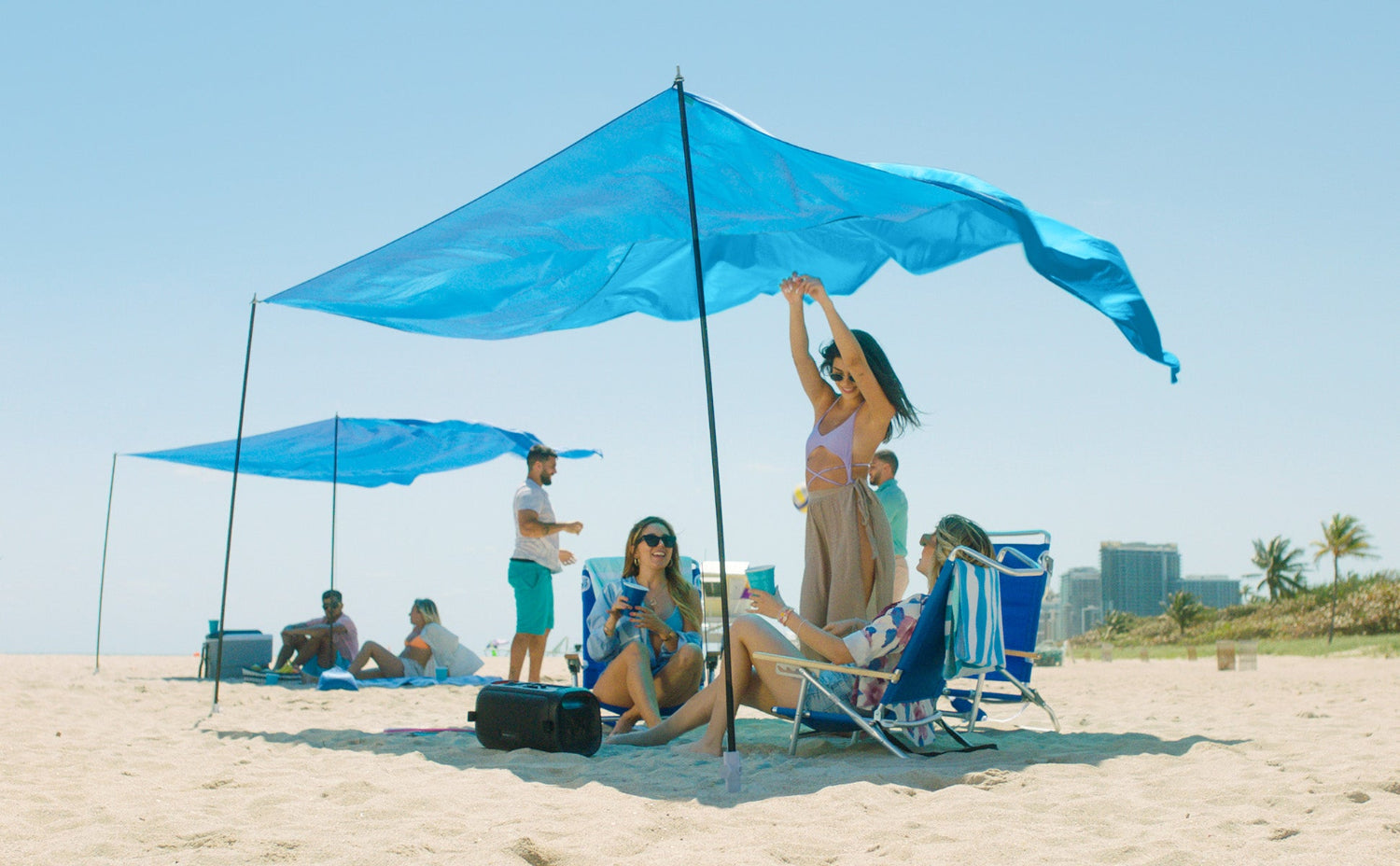 4 people relaxing under AMMSUN blue beach canopy tent sun shade provide 98sq. ft of shade