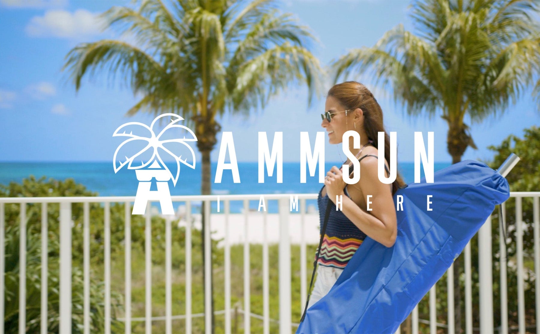 A woman carrying an AMMSUN blue beach umbrella carrying bag on her shoulder